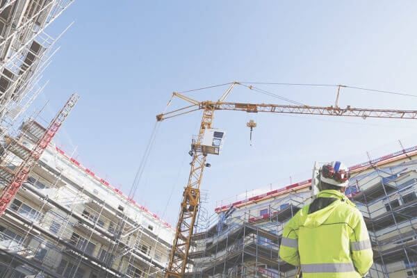 construction worker looking up at a crane